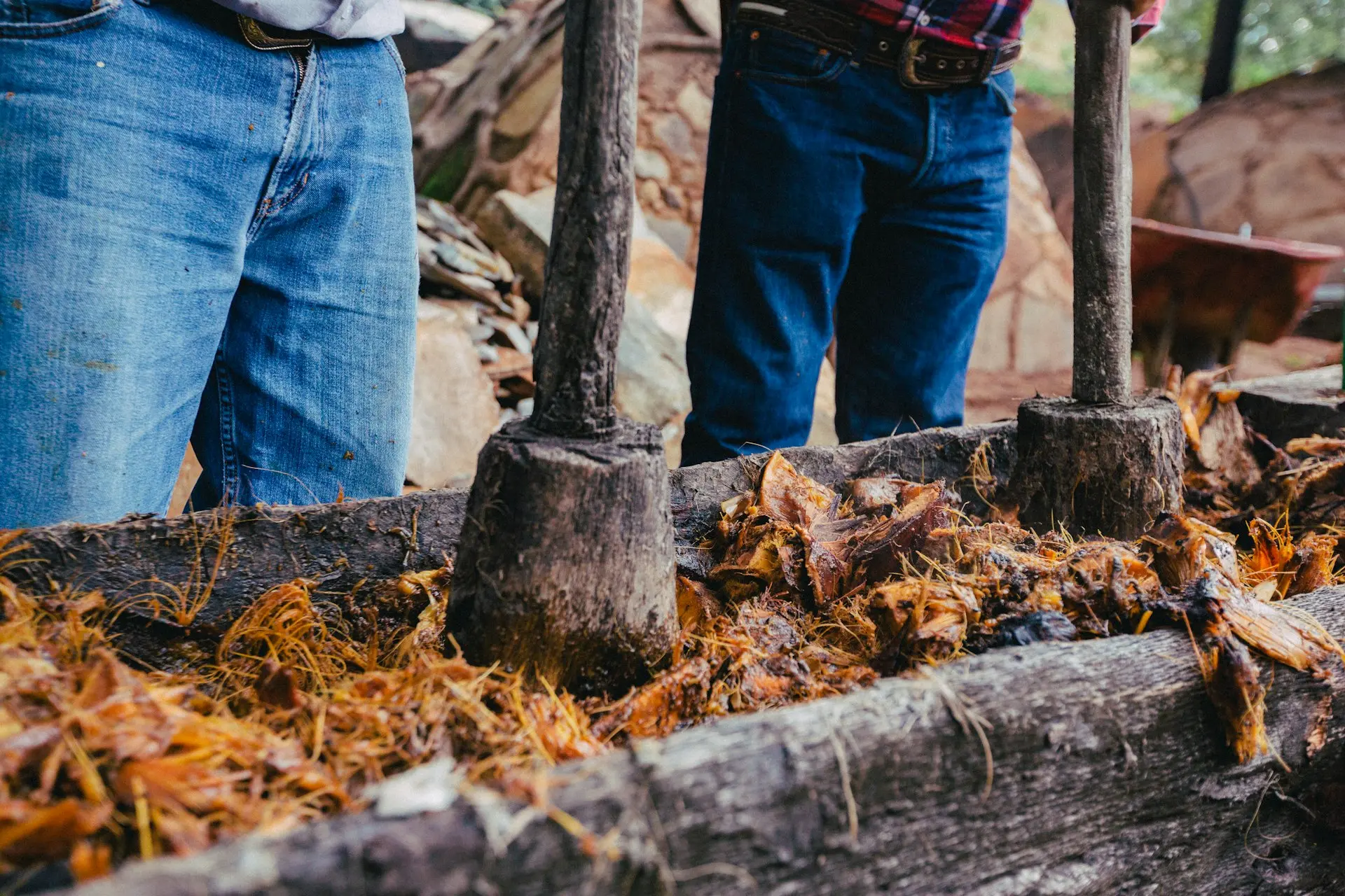 a couple of men standing next to a pile of wood